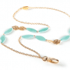 A gold chain with blue beads and a ring