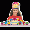 A girl wearing birthday hats with candles on it.