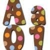 A brown polka dot letter with pink, blue and orange dots.