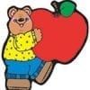 A bear holding an apple in his hands.