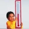 A child holding a thermometer in front of him.