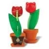 A red flower in a pot next to another plant.