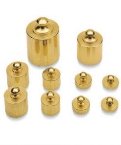 A group of gold colored weights sitting on top of each other.