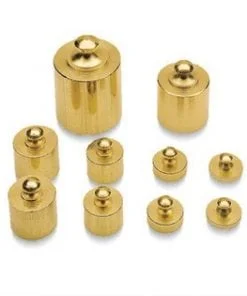 A group of gold colored weights sitting on top of each other.