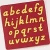 A red and yellow alphabet mat with letters in it.