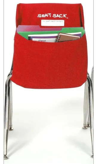 A red chair with a book pocket on the back.