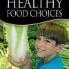 A boy holding up a large piece of lettuce.
