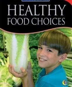 A boy holding up a large piece of lettuce.