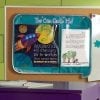 A bulletin board with a poster and some papers on it.