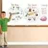 A young boy is standing in front of a board with money and coins on it.