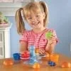 A little girl sitting at the table with some toys.