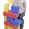 A man standing next to a tall building made of blocks.