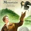 A boy is holding an eagle and a coin