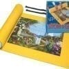 A yellow mat with a box of puzzle pieces on top