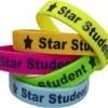 A stack of star student bracelets in different colors.
